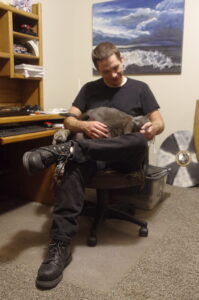 Photo of author, Dodge Merrin holding one of his cats.